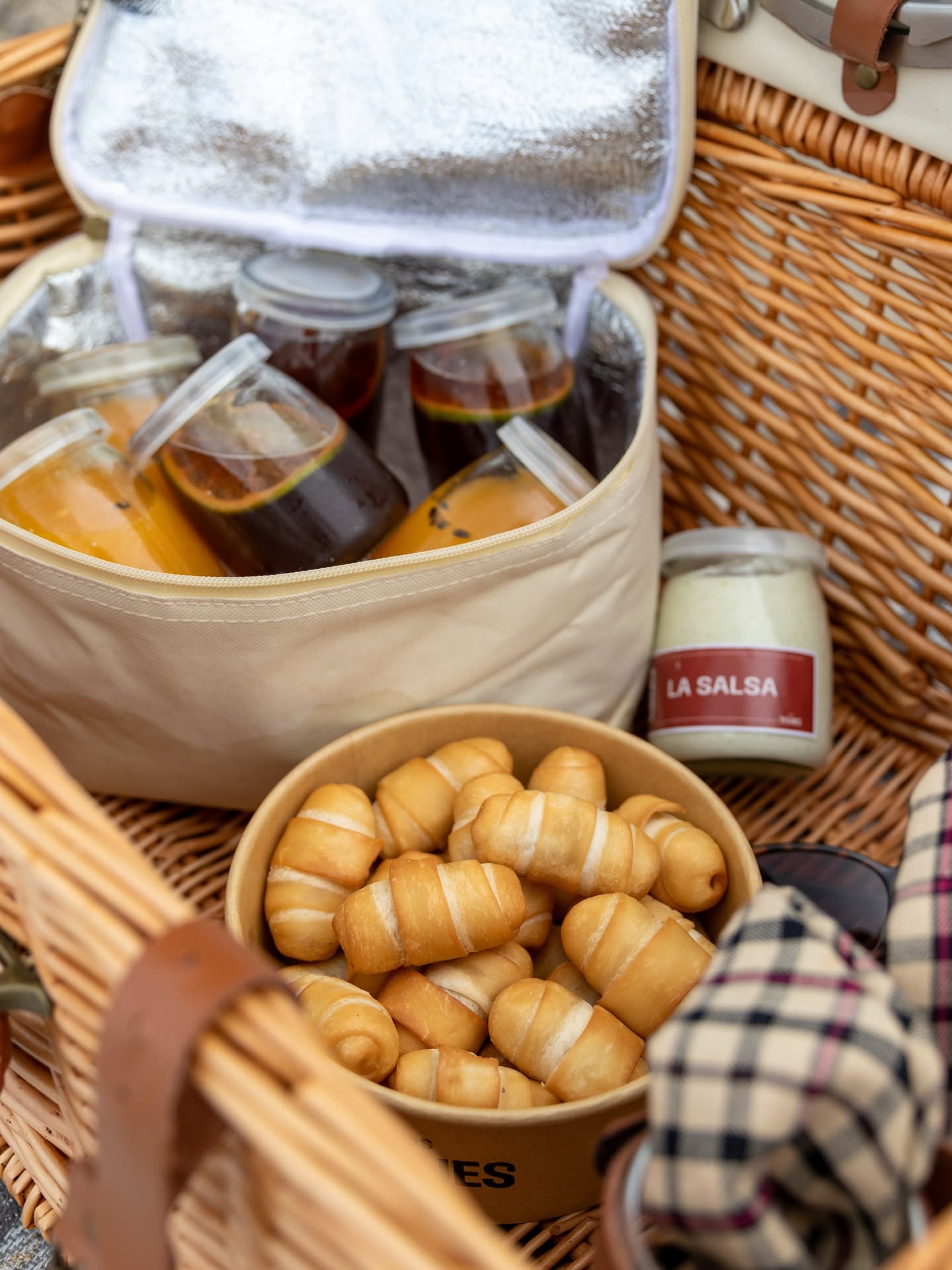 Canasta de picnic con un envase de tequeños Los Teques y un frasco de Salsa La Blanca.